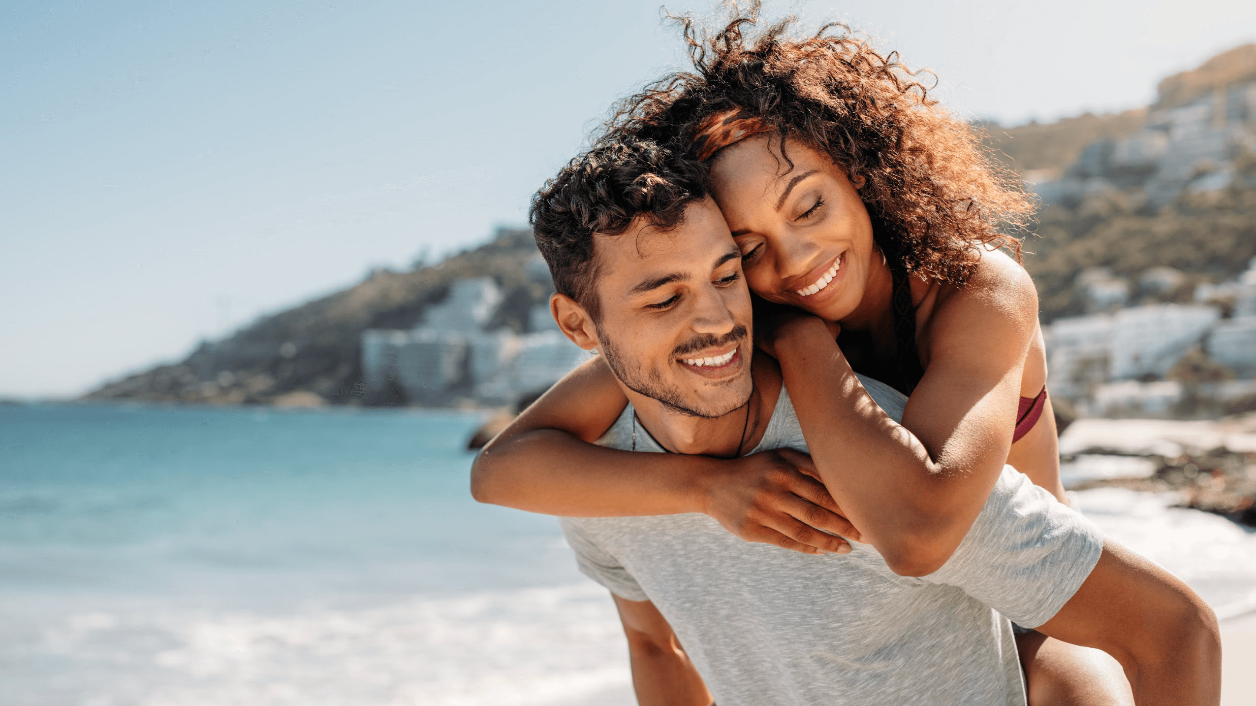 woman on man's back at beach
